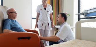 Zorgverlener geeft uitleg aan patiënt over zijn knie