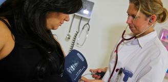 Gynaecoloog meet bloeddruk bij zwangere vrouw