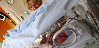 Verpleegkundige controleert baby in Couveuse