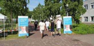 Gedetineerden lopen langs banners van de Stichting Vrienden