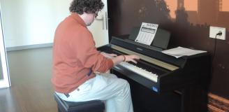 Communicatiemedewerker Willem-Jan Hanegraaf probeert de nieuwe piano van de Tolbrug uit