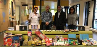 Jan de Gouw en Alex van Keulen van de PI Vught overhandigen cadeaus aan de polikliniek Kindergeneeskunde