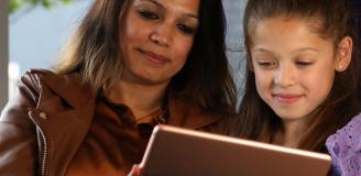 Afbeelding patient en kind kijkend naar MijnJBZ op een tablet