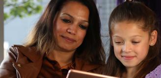 Afbeelding patient en kind kijkend naar MijnJBZ op een tablet