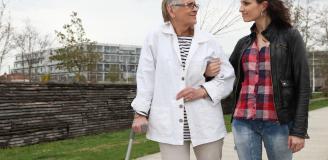 oudere vrouw wandelt met begeleider