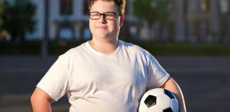 Mollige tienerjongen met voetbal
