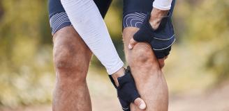 Foto van een wielrenner met pijn aan zijn knie