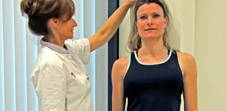 Foto van een patiënt bij wie de lengte wordt opgemeten