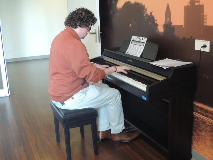 Communicatiemedewerker Willem-Jan Hanegraaf probeert de nieuwe piano van de Tolbrug uit