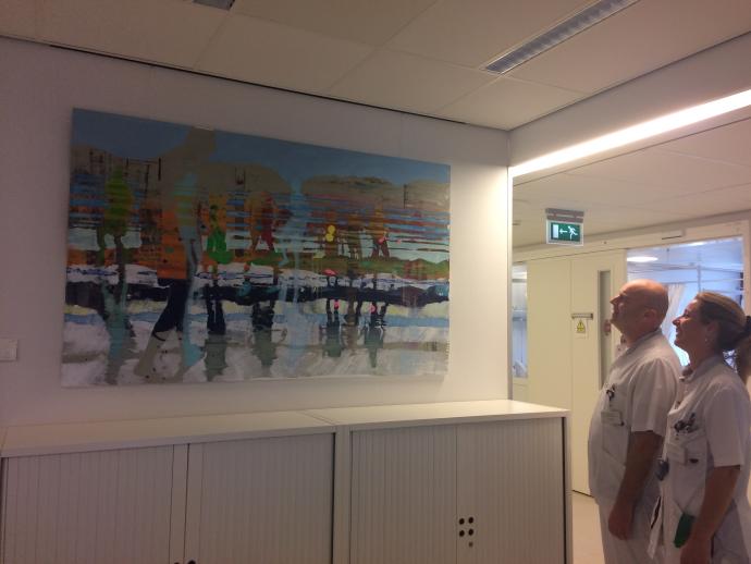 Twee verpleegkundigen kijken naar een schilderij op het MOC