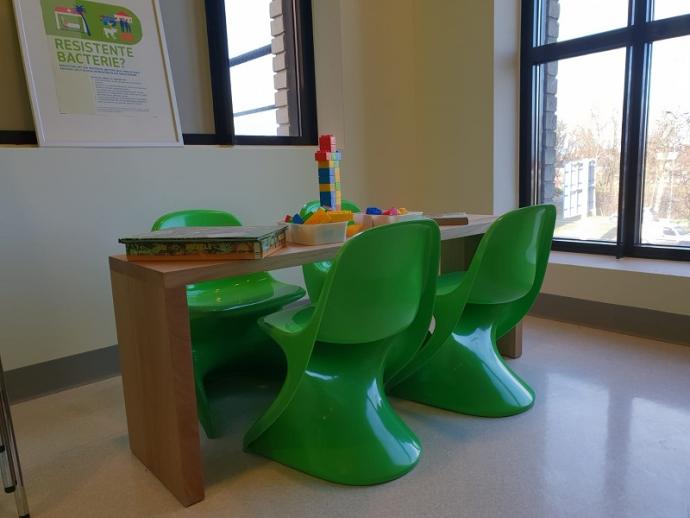 De wachtkamer met groene stoelen en speelgoed