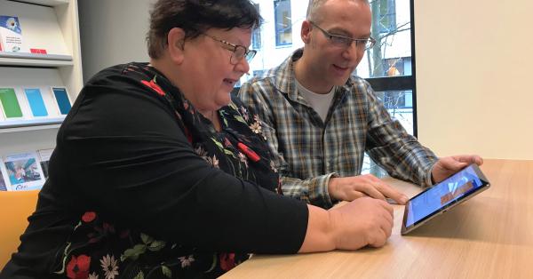Margriet en Niels bekijken de website op een iPad