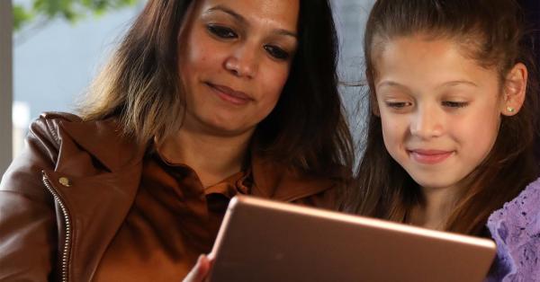 Afbeelding patient en kind kijkend naar MijnJBZ op een tablet