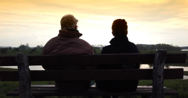 Een foto van twee mensen op een bankje