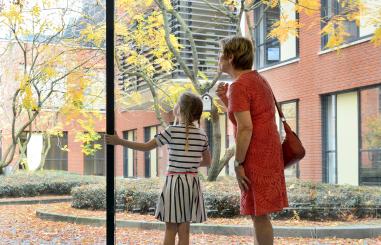 Vrouw met kind kijkend naar binnentuin