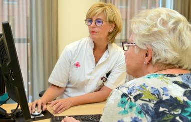 MDL verpleegkundige in gesprek met vrouw in spreekkamer