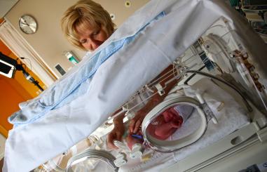 Verpleegkundige controleert baby in Couveuse