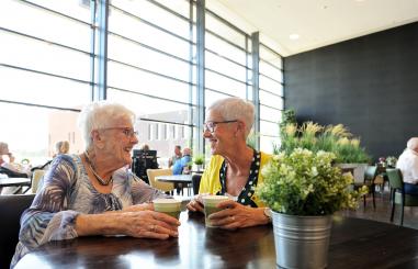 oudere vrouw koffie drinkend in koffiehoek