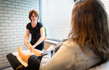 Sportarts onderzoekt de enkel van een vrouw