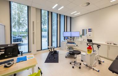 Ruimte met loopband, computer, fiets en bed
