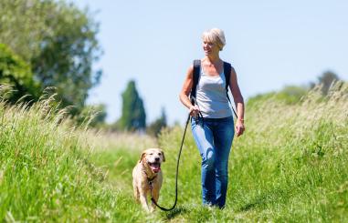 vrouw in overgang wandelt met hond 