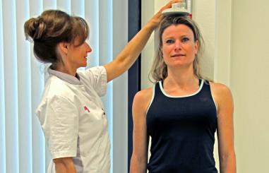 Foto van een patiënt bij wie de lengte wordt opgemeten