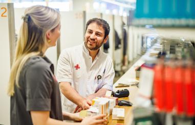 Foto van een medewerker van de apotheek in overleg met een verpleegkundige