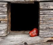 Houten frame met rechtonderin een rood, stenen hartje