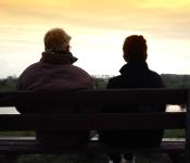 Een foto van twee mensen op een bankje